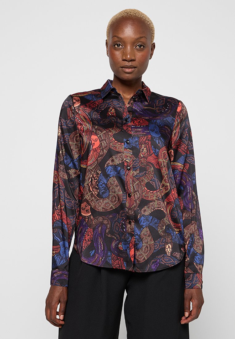 Langärmlige Bluse mit einem mehrfarbigen Schlangen- und Gesichtsmuster auf dunklem Hintergrund, mit durchgehender Knopfleiste und glatter Satinoberfläche.