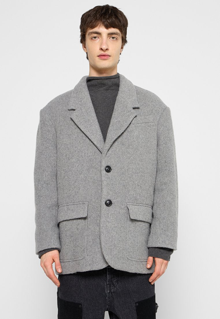 Grau meliertes Wolljacke mit lockerer Passform, zwei Vordertaschen, einem aufgeschlagenen Revers und schwarzen Knöpfen; hat eine strukturierte Oberfläche.