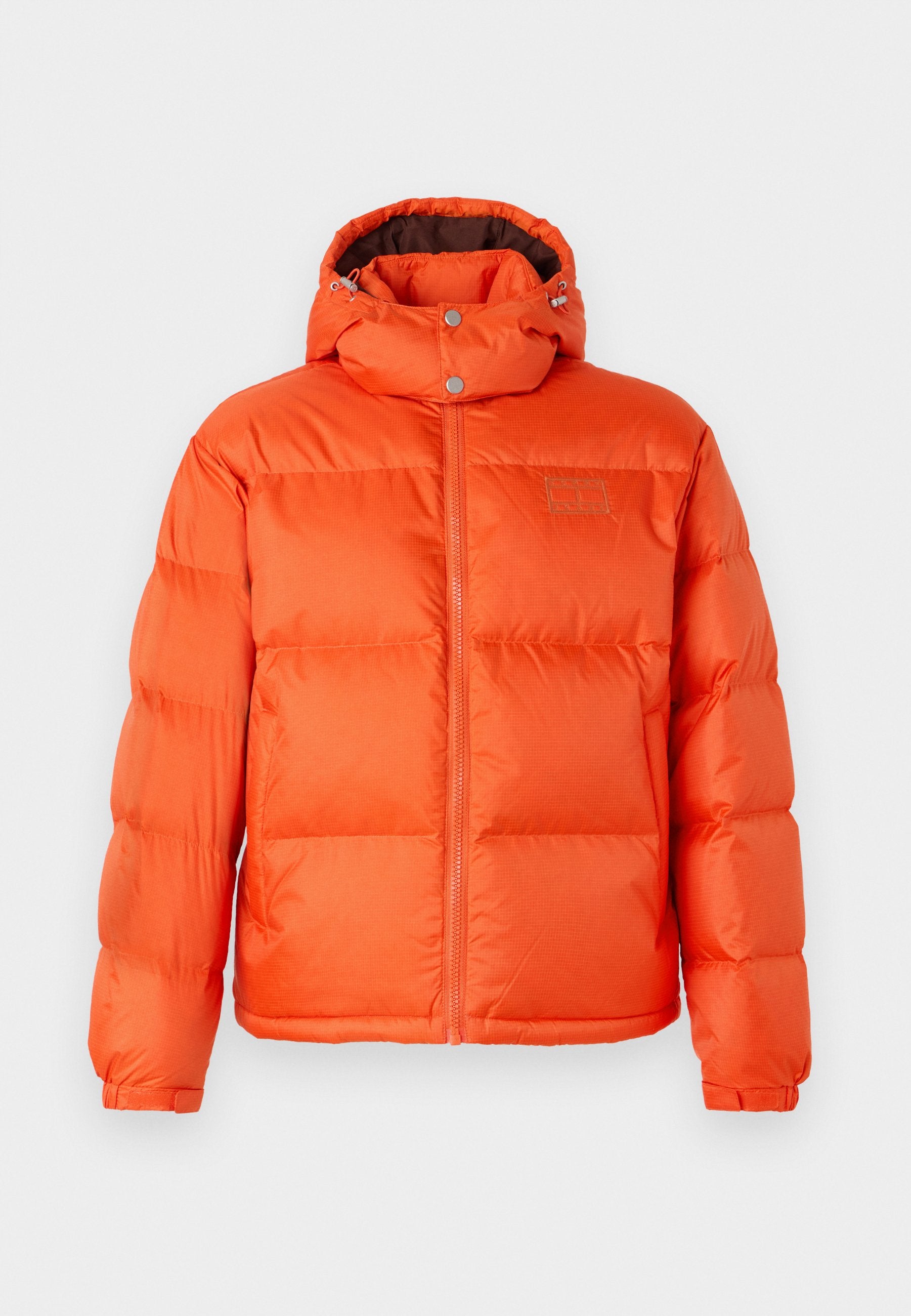 Helle orange Daunenjacke mit einem Reißverschluss vorne, einer abnehmbaren Kapuze und einem gesteppten Design. Besitzt metallische Beschläge und eine glatte Textur.