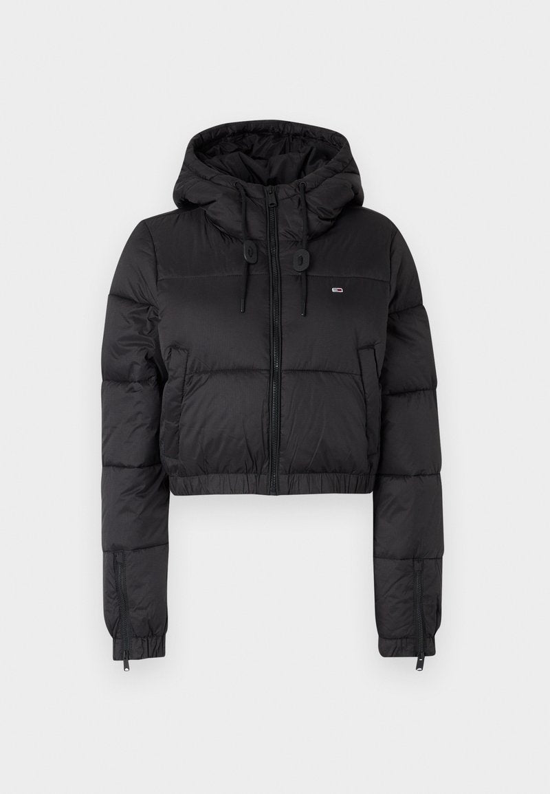 Schwarze, croppte Daunenjacke mit Kapuze, ausgestattet mit einem Frontreißverschluss, zwei Seitentaschen und einem elastischen Saum. Glatte Textur mit minimalem Branding.