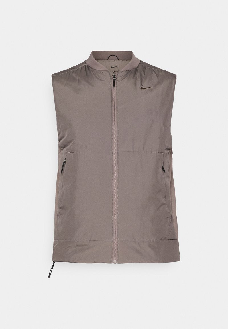 Ärmellose Weste mit Reißverschluss in hellem Taupe. Aus glattem, leichtem Stoff mit dezentem Glanz. Mit zwei Seiten- und elastischen Taschen am Saum.