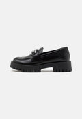Schwarze Lederloafer mit einer massiven, gerippten Sohle und einem metallischen Schnallenakzent am Riemen. Glatte Textur, klassisches Design.