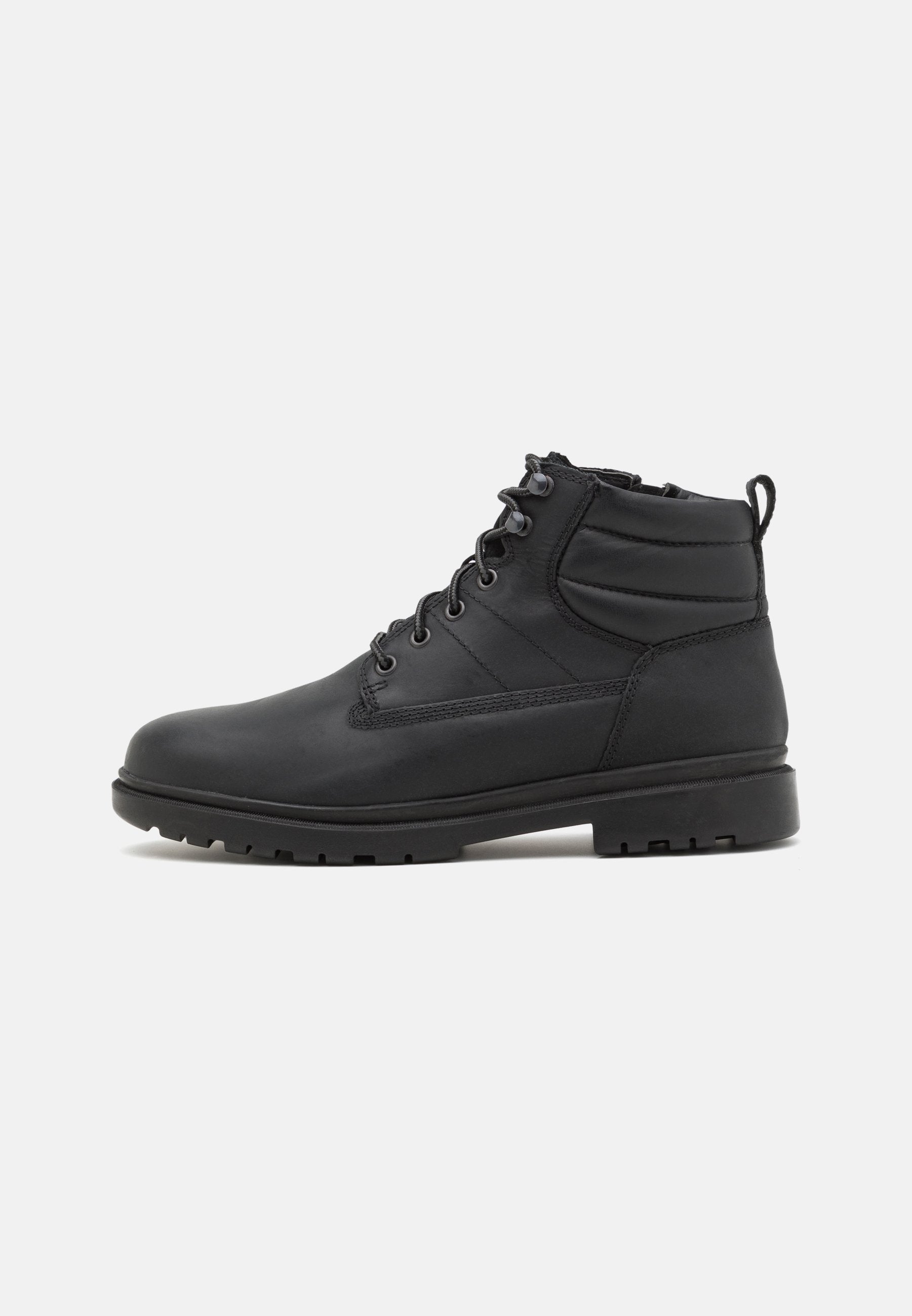 Schwarze Lederstiefel mit robustem Profil, ausgestattet mit Schnürdesign, gepolstertem Knöchelstütze und einer Griffschlaufe hinten für einfaches Anziehen.