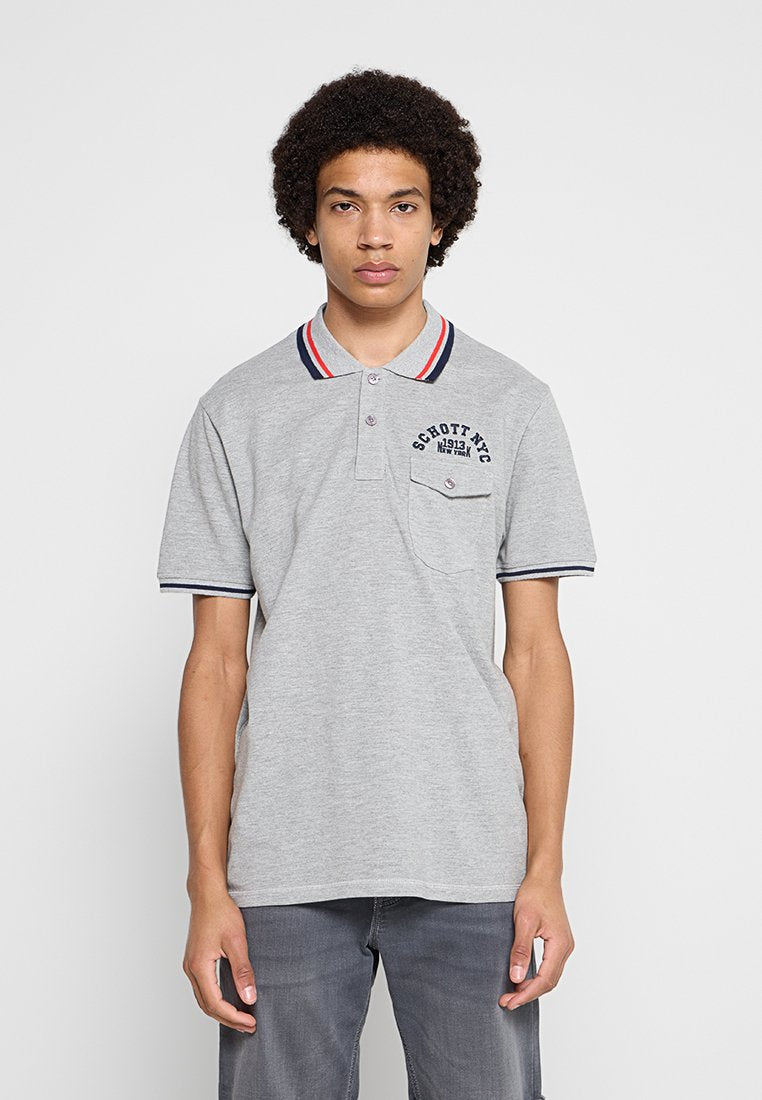 Junger Mann mit lockigem Haar, der ein graues Poloshirt mit roten, weißen und blauen Streifen am Kragen und an den Ärmelenden trägt, steht vor weißem Hintergrund.