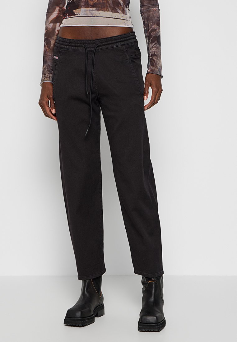 Schwarze, lässige Hose mit elastischem Bund und Kordelzug. Hergestellt aus einem glatten Stoff mit Seitentaschen und geraden Beinen.