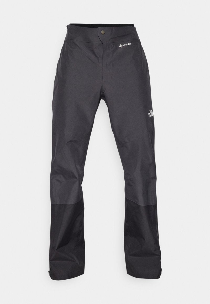 Schwarze wasserdichte Hose mit glatter Textur, ausgestattet mit einem GORE-TEX-Logo auf der Vorderseite und verstärkten Unterschenkeln für zusätzliche Haltbarkeit.