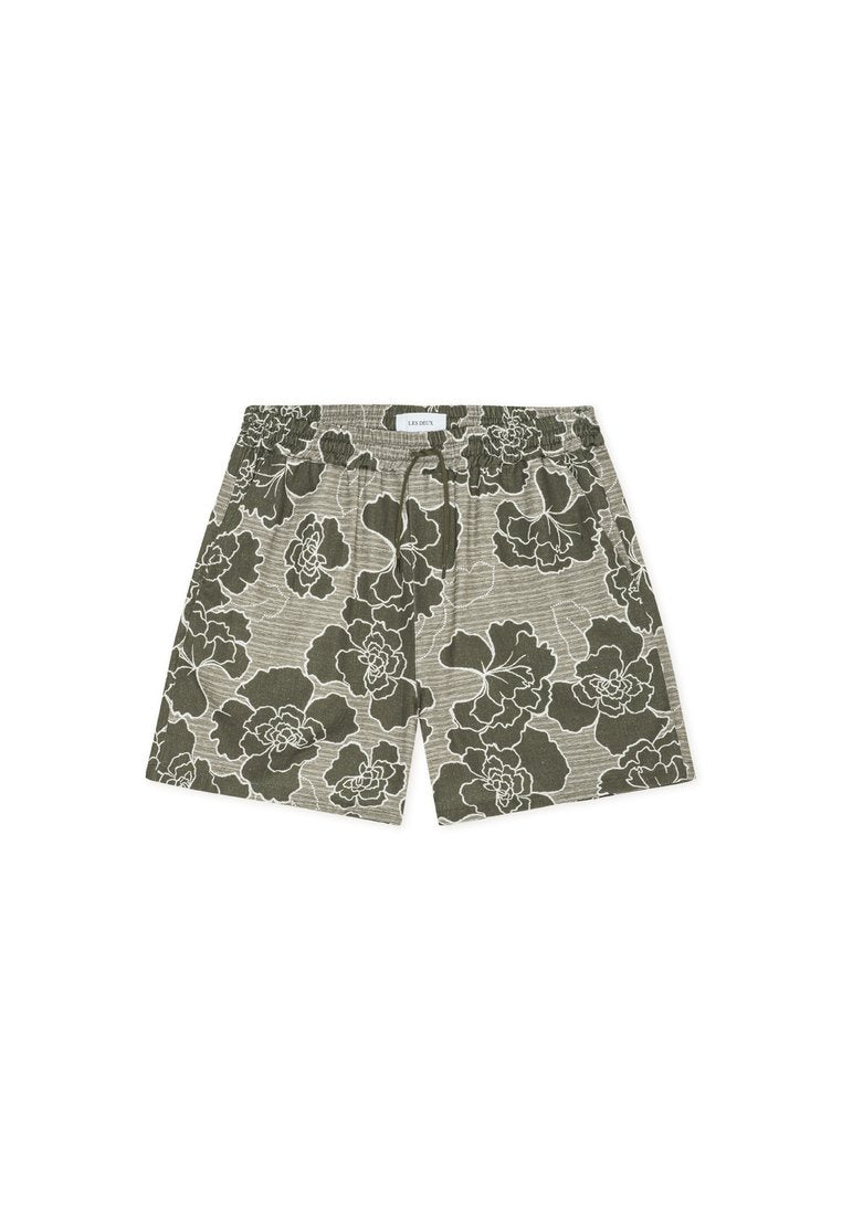 Olivgrüne Shorts mit weißem Blumenmuster, elastischem Bund und Kordelzug. Ausgestattet mit einem strukturierten Stoff mit horizontalen Streifen.