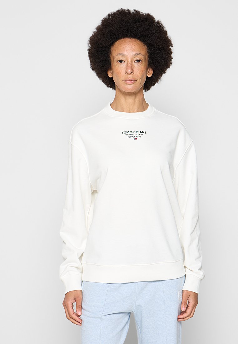 Weißer Pullover mit Rundhalsausschnitt, überschnittenen Schultern und gerippten Bündchen. Verfügt über ein kleines, farbiges Logo auf der Brust. Weicher Stoff. 