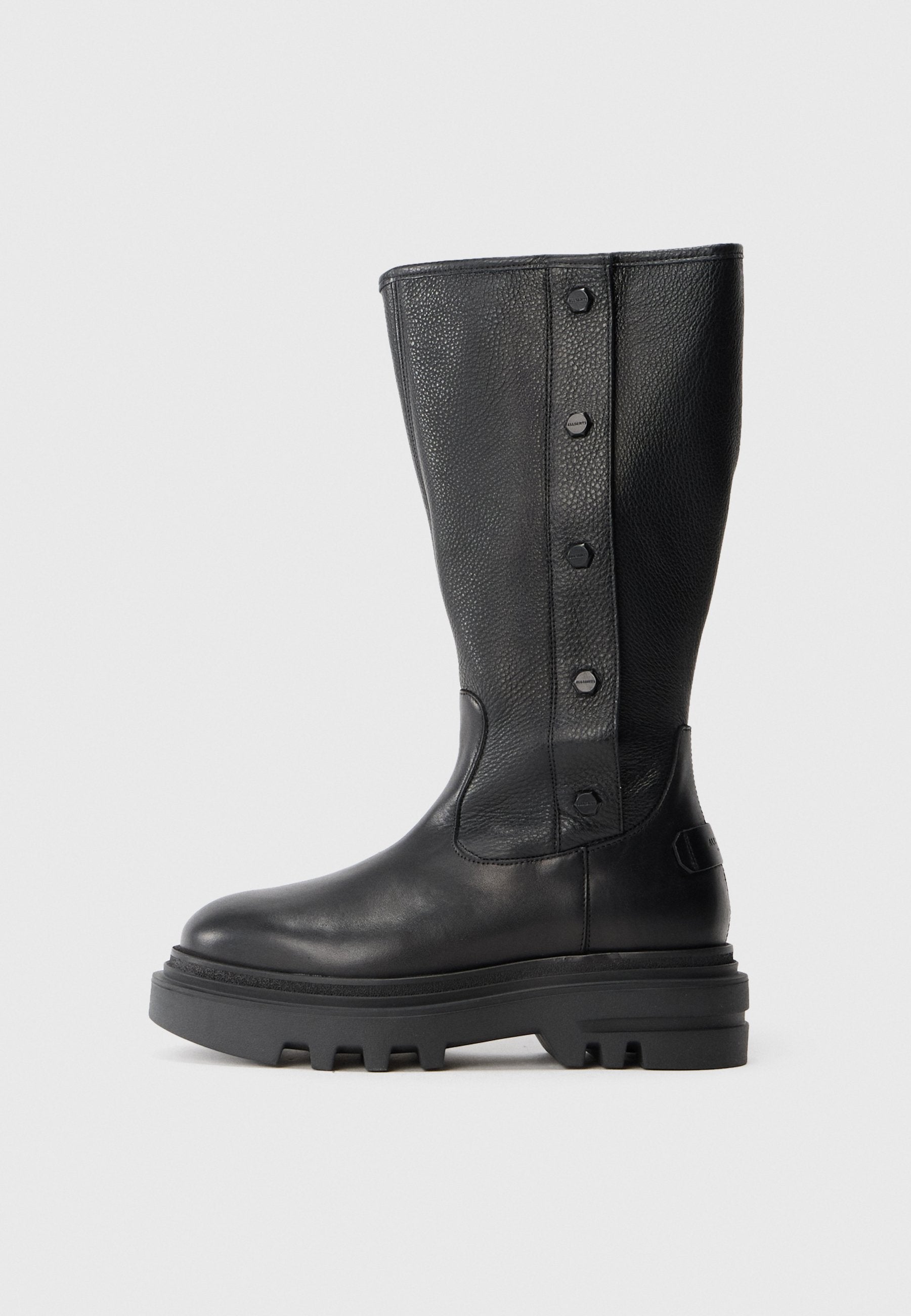 Schwarze kniehohe Lederstiefel mit dicker Profilsohle und vier dekorativen Druckknöpfen entlang des strukturierten Seitenpanels.