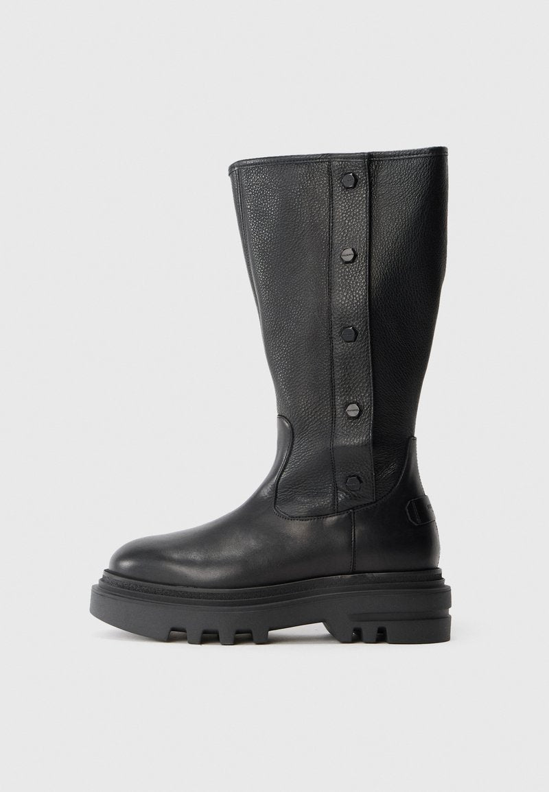 Schwarze kniehohe Lederstiefel mit dicker Profilsohle und vier dekorativen Druckknöpfen entlang des strukturierten Seitenpanels.