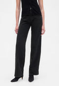 Schwarze Jeans mit weitem Bein aus Denim, hoch tailliert, mit Knopfverschluss und lockerem Schnitt, kombiniert mit spitzen schwarzen High Heels.