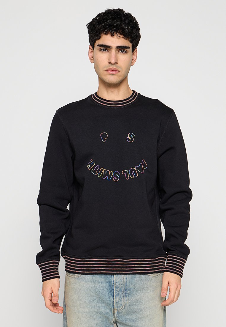 Schwarzer Pullover mit mehrfarbigem, gesticktem Text und Smiley-Gesicht. Verfügt über einen gerippten Kragen und Bündchen mit kontrastierenden Streifen.