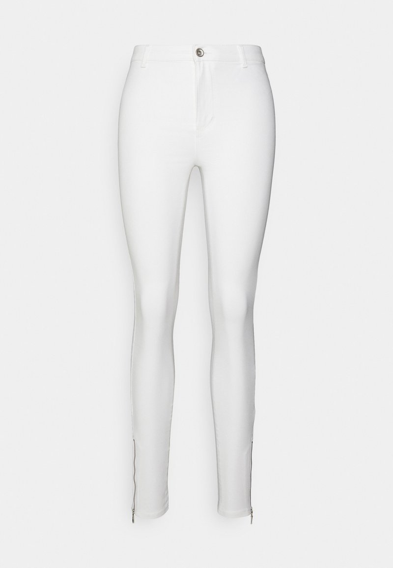 Weiße enge Jeans aus dehnbarem Material, mit einem Front-Reißverschluss, Fronttaschen und Reißverschlüssen an den Säumen für eine verstellbare Passform.