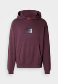 Bordeauxroter Kapuzenpullover mit Fronttasche, gerippten Bündchen und Saum. Verfügt über einen schwarzen rechteckigen Aufnäher mit dem Logo "HUGO" in der Mitte. Glatte Textur.