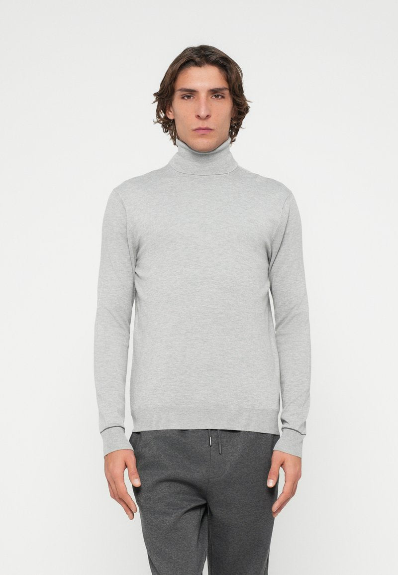 Hellgrauer Rollkragenpullover aus weichem, geripptem Material mit enganliegenden Ärmeln und Saum, getragen zu dunkelgrauen Hosen. Schlichtes Design ohne Muster.