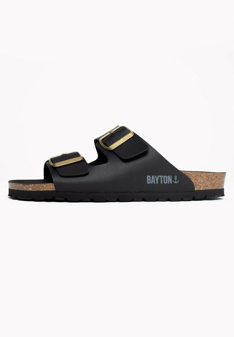 Schwarze Sandalen mit zwei verstellbaren Riemen und goldenen Schnallen, ausgestattet mit einem Korkfußbett und einer strukturierten schwarzen Außensohle. Bayton-Logo an der Seite.