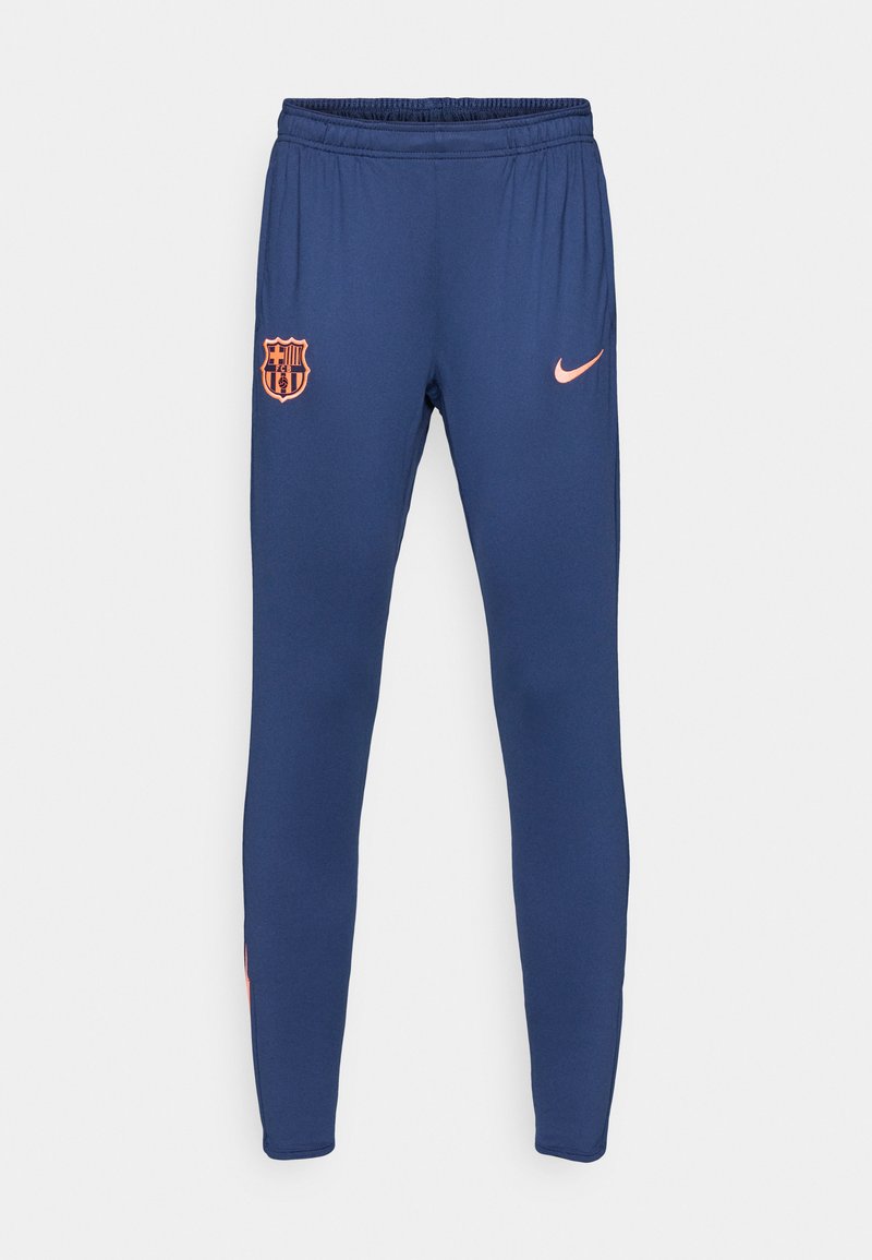 Marinefarbene Sporthosen aus weichem Stoff mit einem elastischen Bund. Mit dem Logo des FC Barcelona und einem kleinen pinken Nike-Swoosh an der Hüfte.