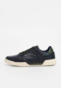 Marineblauer Ledersneaker mit grünen Akzenten, gemustertem Seitendetail und cremefarbener Gummisohle. Verfügt über Perforationen und Schnürverschluss.