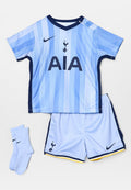 Hellblaues Sportoutfit bestehend aus einem kurzärmeligen Trikot mit vertikalen Streifen, marineblauen Akzenten und Logo, kombiniert mit leichten Shorts und Socken.