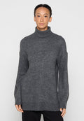 Grauer Rollkragenpullover aus weichem Strickstoff. Er zeichnet sich durch eine lockere Passform mit langen Ärmeln und einen etwas längeren Rückensaum für zusätzlichen Schutz aus.