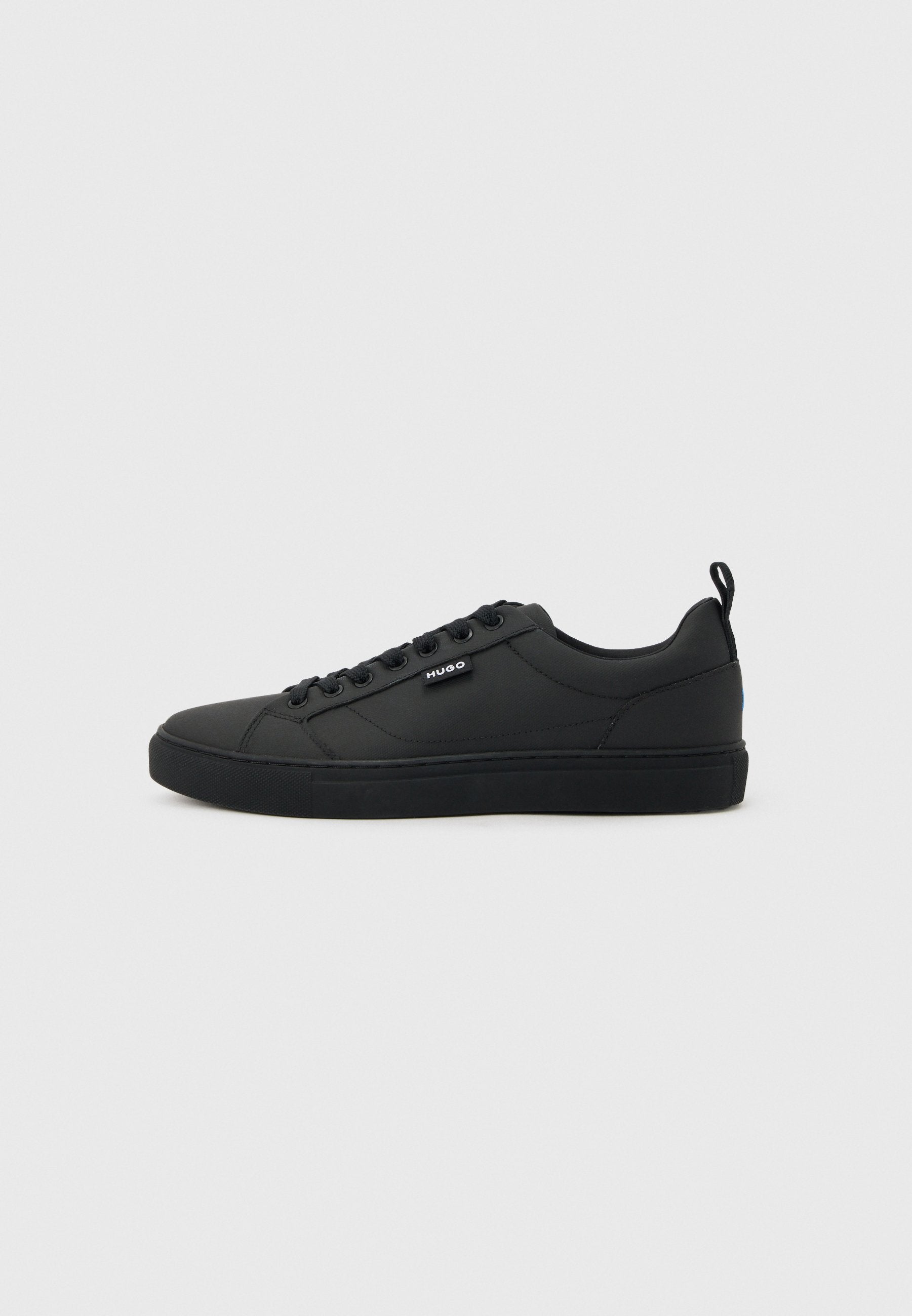 Schwarzer Sneaker mit niedrigem Schnitt, Schnürverschluss, flacher Sohle und kleinem "HUGO"-Label an der Seite, im Profil auf hellem Hintergrund gezeigt.