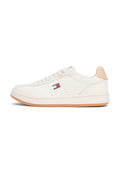 Weißer Sneaker mit niedrigem Schaft, beigefarbener Fersenlasche, Gummisohle, weißen Schnürsenkeln und einem kleinen Tommy Jeans Logo an der Seite.