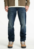 Blaue Denim-Jeans mit einer lockeren Passform und dezentem Verblassen, kombiniert mit beigen Wanderstiefeln mit grauen Schnürsenkeln und einer strukturierten Außensohle.