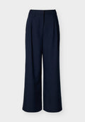 Marineblaue, weit geschnittene Hosen mit hoher Taille und vorderen Falten, vor einem schlichten weißen Hintergrund präsentiert.