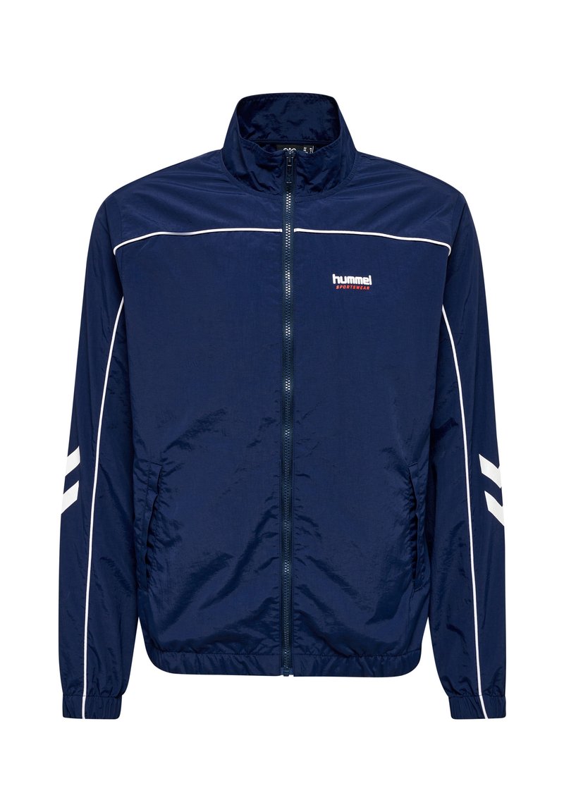 Marineblaue Sportjacke mit Reißverschluss, weißen Paspeln, elastischen Bündchen, zwei Seitentaschen und „hummel sportswear“-Logo auf der linken Brust.