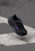 Schwarzer Sportschuh mit Mesh-Obermaterial, roten und blauen Akzenten, strukturiertem Sohlen und prominentem Nike-Logo. Leichtes Design für optimale Leistung.
