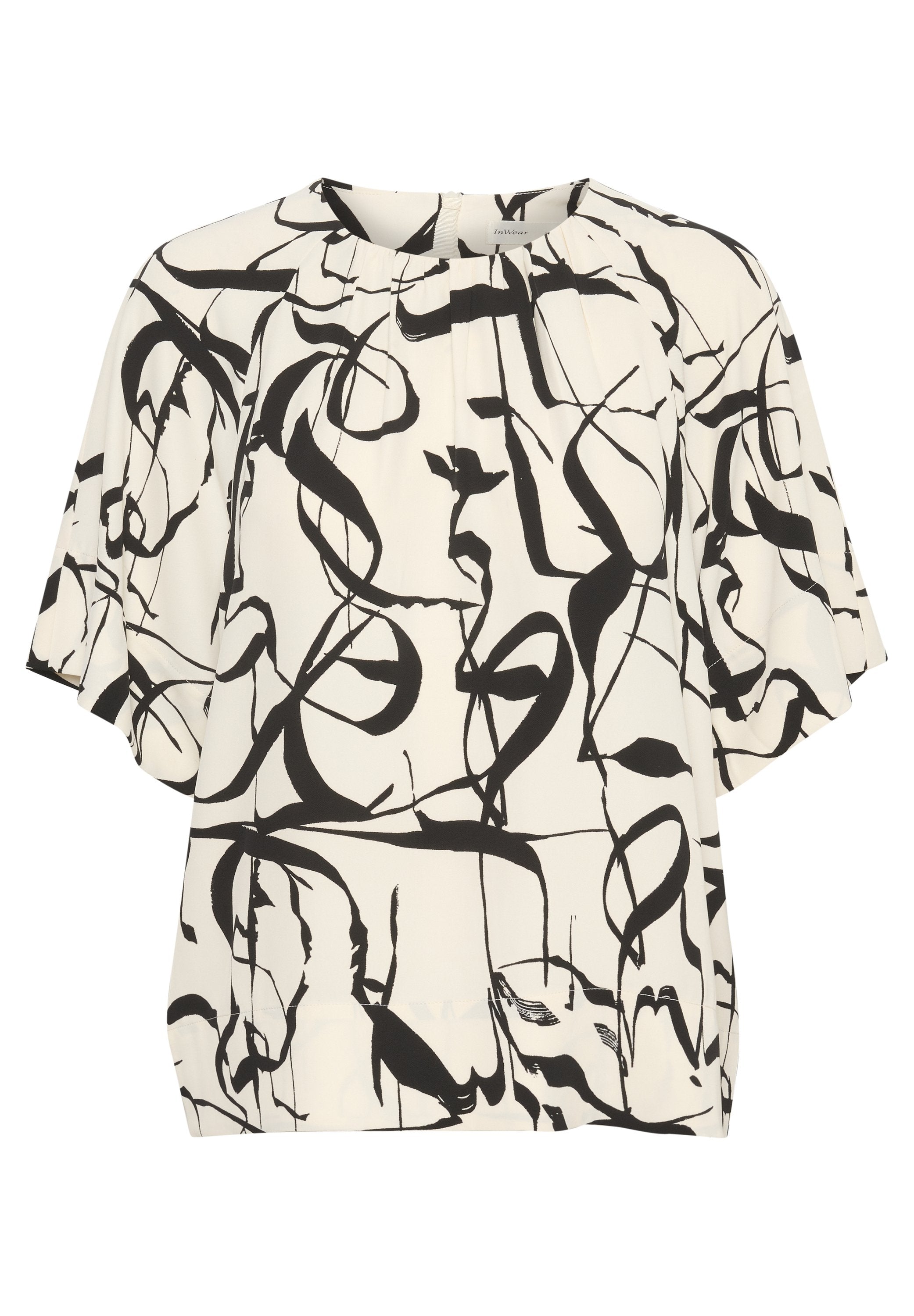 Weiße Bluse mit einem abstrakten Muster aus schwarzer Tinte. Verfügt über kurze Ärmel, einen runden Halsausschnitt und Falten an der Vorderseite für zusätzliche Textur.