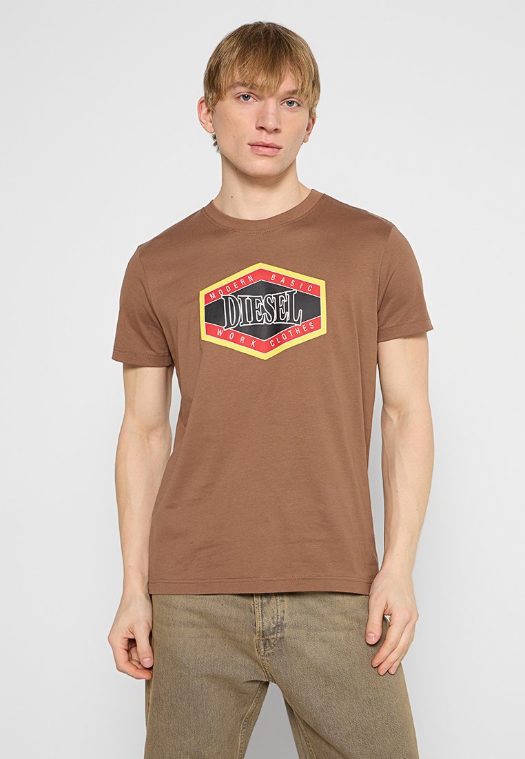 Braunes Baumwoll-T-Shirt mit einem zentralen Grafikdesign in Schwarz, Rot und Gelb mit dem Wort "DIESEL", kurzen Ärmeln und Rundhalsausschnitt.