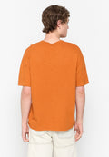 Orange Baumwoll-T-Shirt mit lockerem Schnitt, kurzen Ärmeln und V-Ausschnitt. Der Stoff hat ein strukturierter Aussehen mit subtilen Variationen.