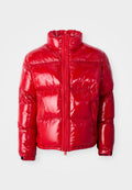 Rote Pufferjacke aus glänzendem, gestepptem Material. Verfügt über einen hohen Kragen, einen Frontreißverschluss und aufgesetzte Taschen mit Reißverschluss. Leicht und mit einem eleganten Design.