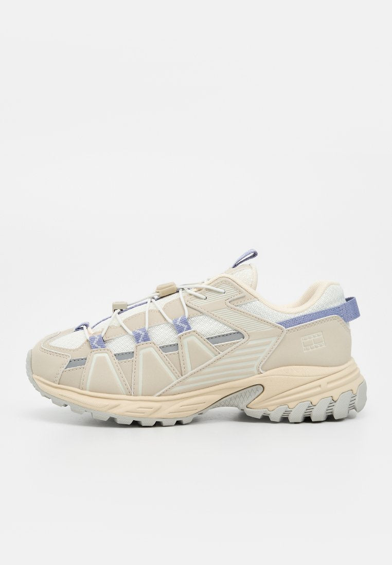 Beiger und hellvioletter Sportschuh mit Mesh- und synthetischen Überzügen, robuster Sohle und Zuglaschen an Zunge und Ferse.