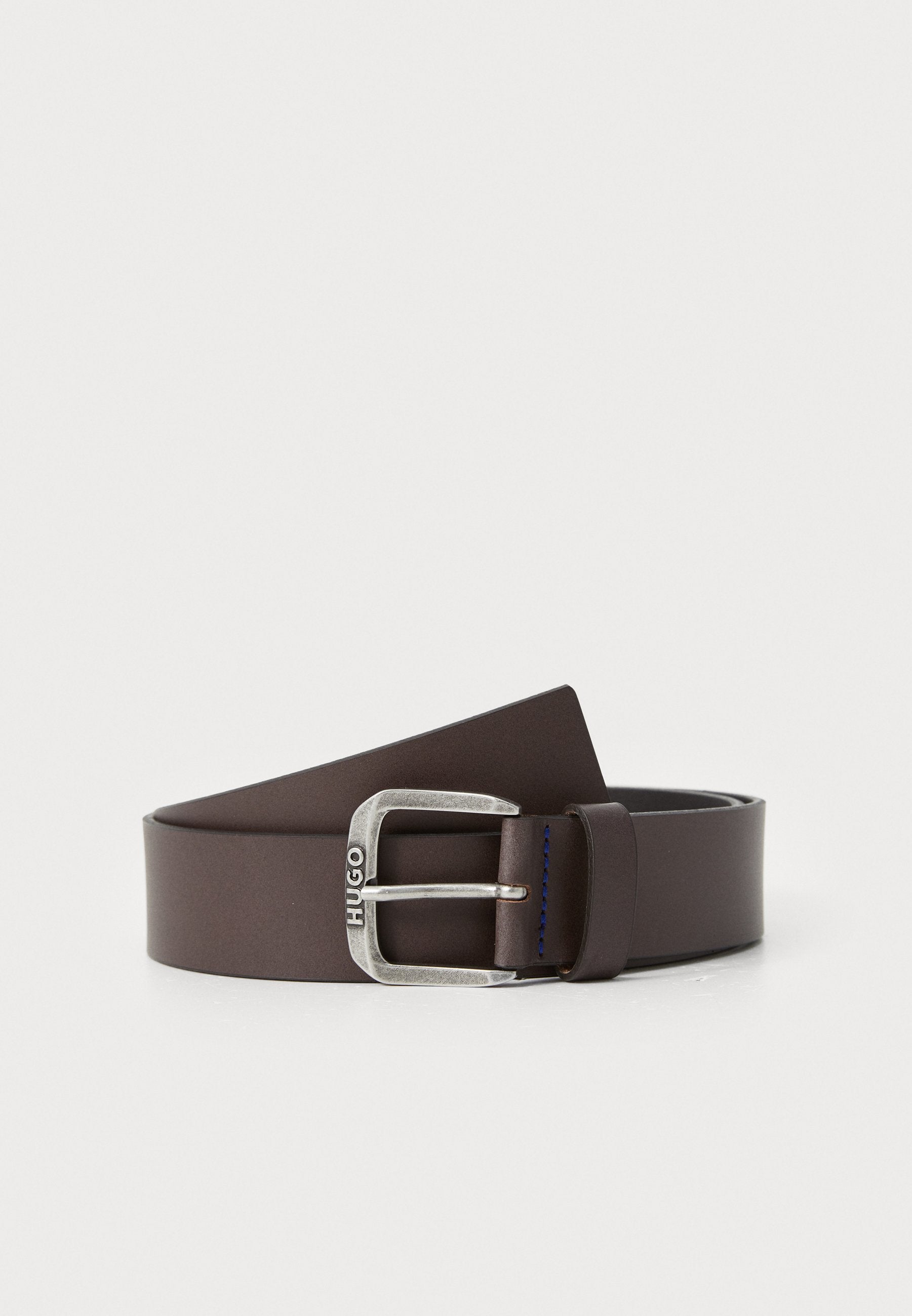 Brauner Ledergürtel mit einer silbernen Metallschnalle, die mit "HUGO"-Branding und blauen Nähdetails auf dem Leder versehen ist. Glattes und elegantes Design.