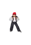 Silberne Puffjacke, weißes Hemd mit silberner Schrift, schwarze gemusterte Jeans, rotes Beanie mit "HUGO" und schwarze Sneakers mit weißen Sohlen.