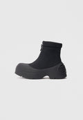 Schwarze wasserdichte Stiefeletten mit glattem, elastischem Obermaterial, geformter Gummisohle und Reißverschluss an der Seite; markantes, breites, rundes Zehendesign.