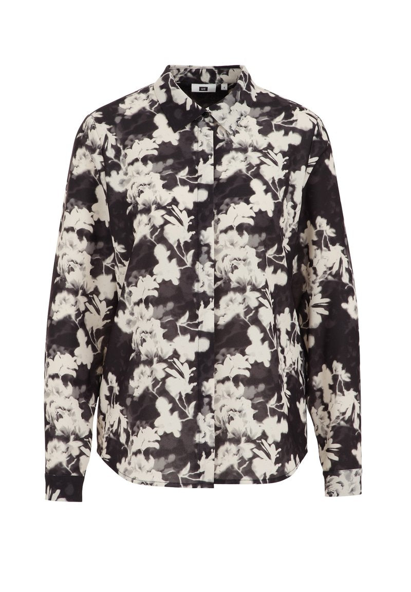 Bluse mit Blumenmuster in Schwarz und Weiß, langärmlig, mit Kragen, leicht abgerundhem Saum und Knopfverschluss auf der Vorderseite.