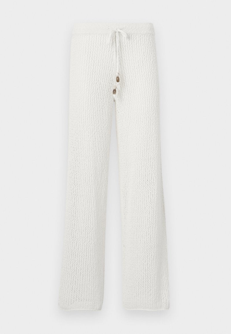 Weiß gestrickte Lounge-Hosen mit einem strukturierten Muster, ausgestattet mit einem Kordelzugbund und zwei dekorativen Knöpfen auf der Vorderseite.
