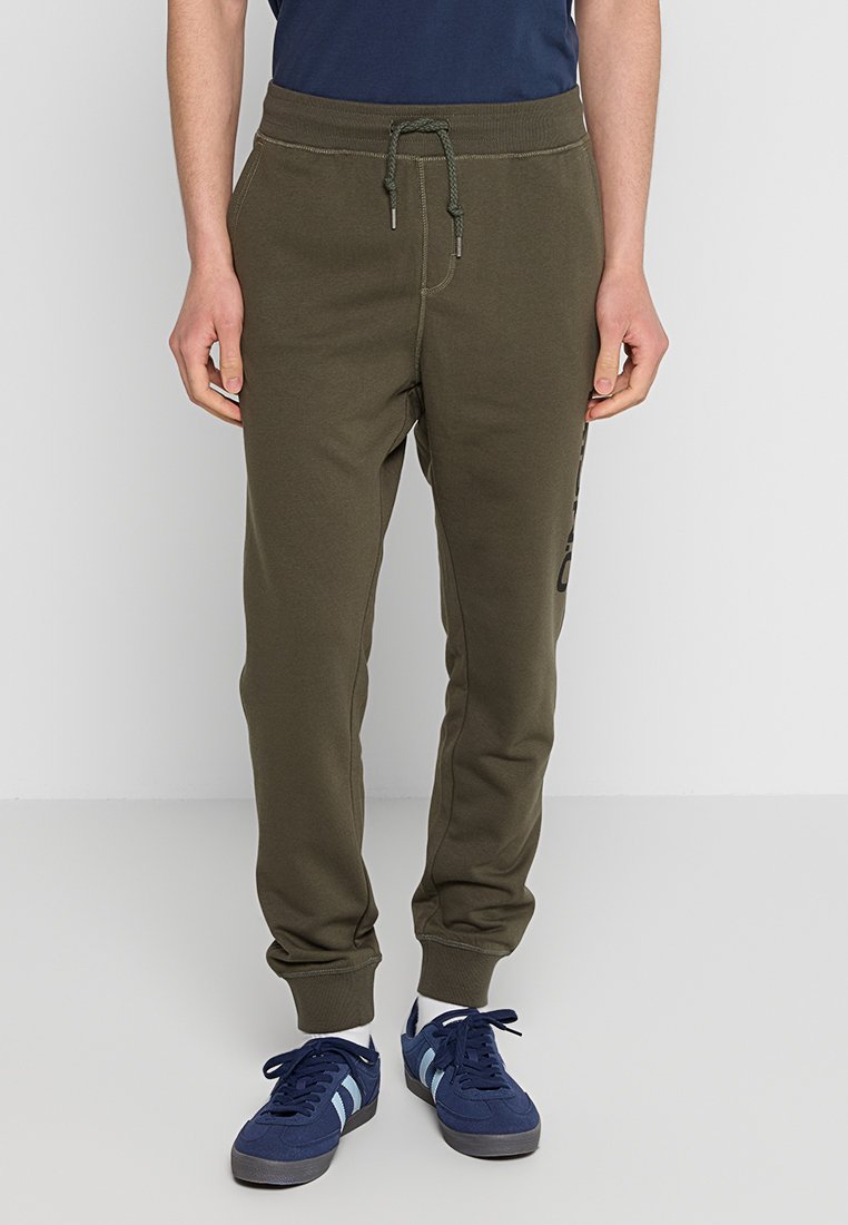 Olivegrüne Baumwoll-Jogger mit einem elastischen Bund, Kordelzug und seitlichen Taschen. Verfügt über kontrastierende Logodetails am linken Bein.