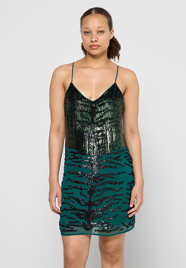 Grünes Paillettenkleid mit V-Ausschnitt, das einen glänzenden oberen Bereich und einen strukturierten, gemusterten unteren Teil mit einem schwarzen Design aufweist. Spaghetti-Träger.