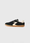 Schwarze Wildleder-Sneaker mit einer cremefarbenen Akzentuierung und Gummisohle. Sie verfügen über flache Schnürsenkel, eine abgerundete Zehenpartie und "SKECHERS" in Gold auf der Ferse bedruckt.