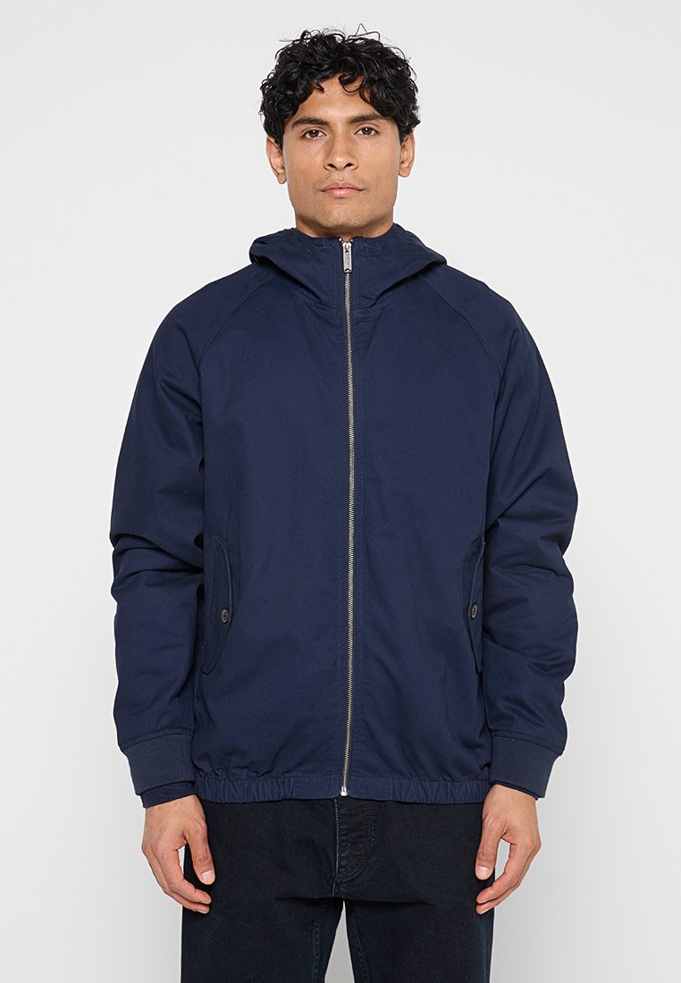 Marineblaue Jacke mit Kapuze, Frontreißverschluss und elastischem Saum. Verfügt über Seitentaschen und einen glatten, strukturierten Stoff.