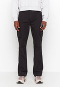 Schwarze Cargo-Hosen mit Seitentaschen, aus robustem Material gefertigt. Figurbetontes Design mit geradem Bein. Kombiniert mit einem leichten Sweatshirt und Sneakers.