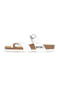 Weiße Riemchensandalen mit Korkfußbett, zwei breiten Riemen, silberner Schnalle und dem aufgedruckten "BAYTON"-Logo an der Seite. Flexible Gummisohle.