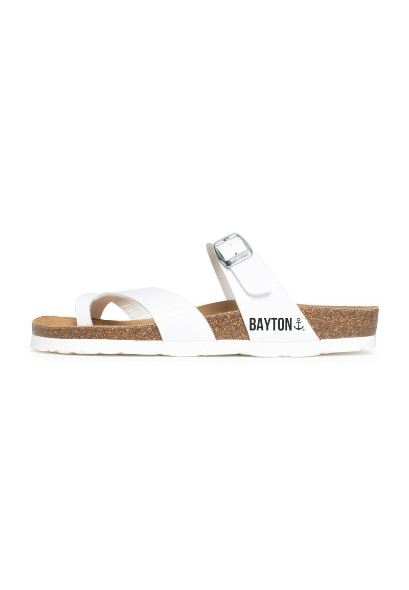 Weiße Riemchensandalen mit Korkfußbett, zwei breiten Riemen, silberner Schnalle und dem aufgedruckten "BAYTON"-Logo an der Seite. Flexible Gummisohle.