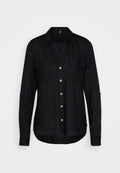 Schwarze Hemdjacke aus einem weichen, strukturierten Stoff. Verfügt über einen V-Ausschnitt, zwei Brusttaschen und goldfarbene Knöpfe. Lange Ärmel mit Manschetten.