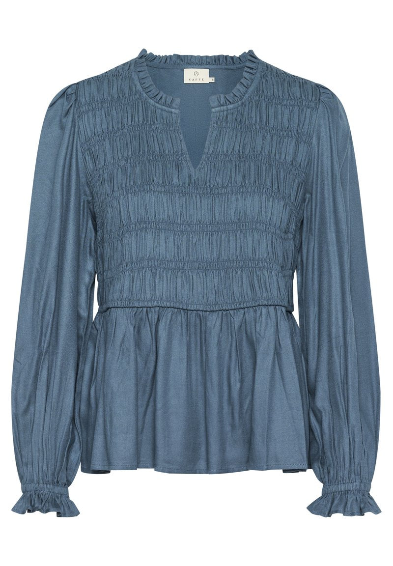 Blaue Bluse mit langen Ärmeln, gerafftem Oberteil, Rüschensaum und einem subtilen Glanz. Sie verfügt über einen Schlüssel-Ausschnitt und einen ausgestellten Saum.