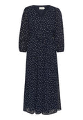 Marineblaues Kleid mit V-Ausschnitt, weißen Punkten und langen Puffärmeln. Mit einem gebundenen Taillengürtel und einer fließenden A-Linien Silhouette.